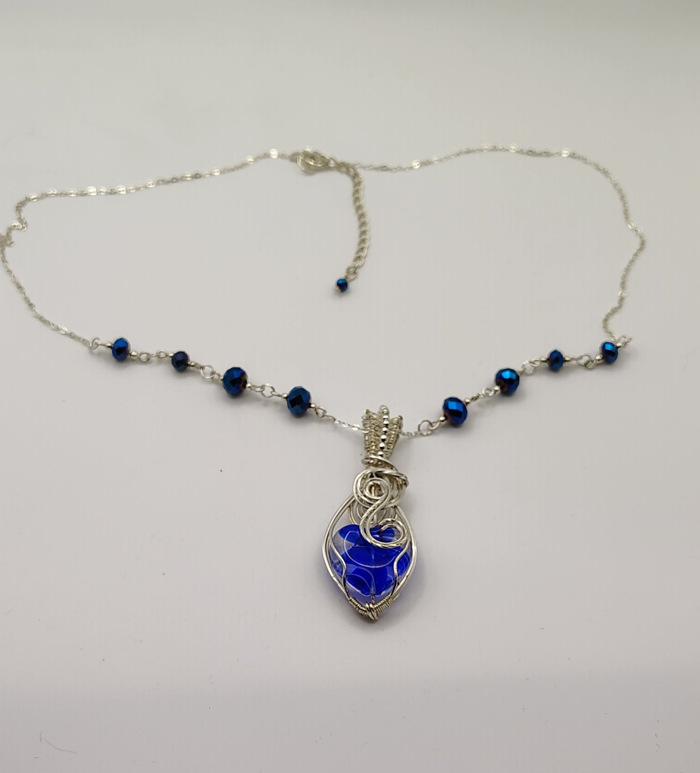 SILVER-PLATED AND BLUE HEART NECKLACE WITH ACCENT BEADS.